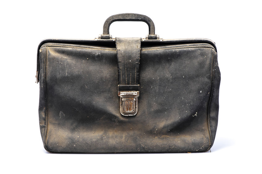 A dusty, ratty black briefcase standing upright