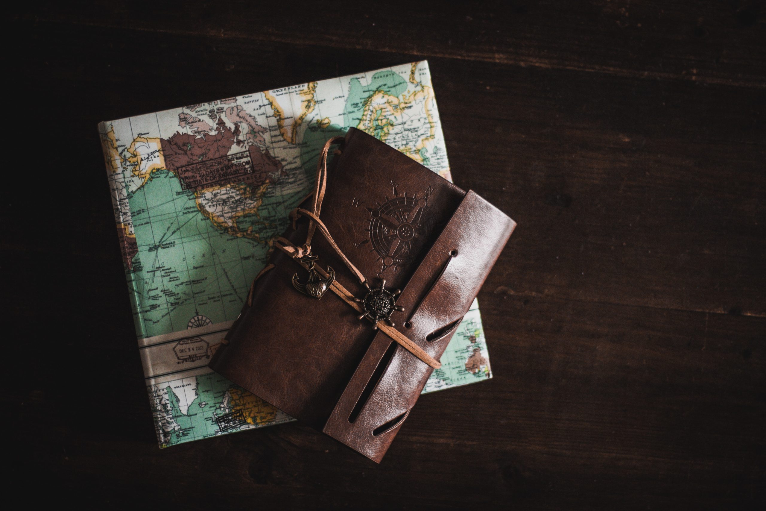  A leather-bound journal sitting on top of a world map